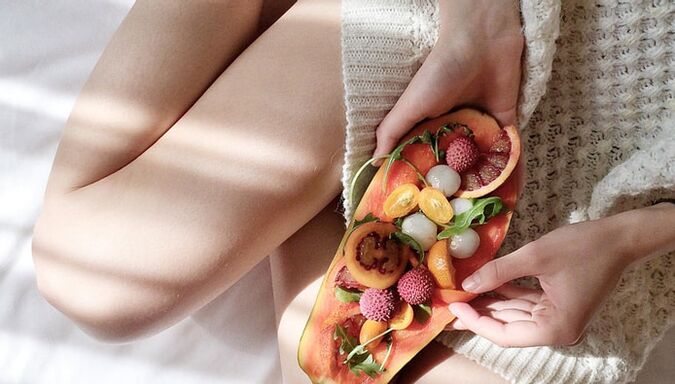 Mädchen mit Papaya und anderen Früchten.